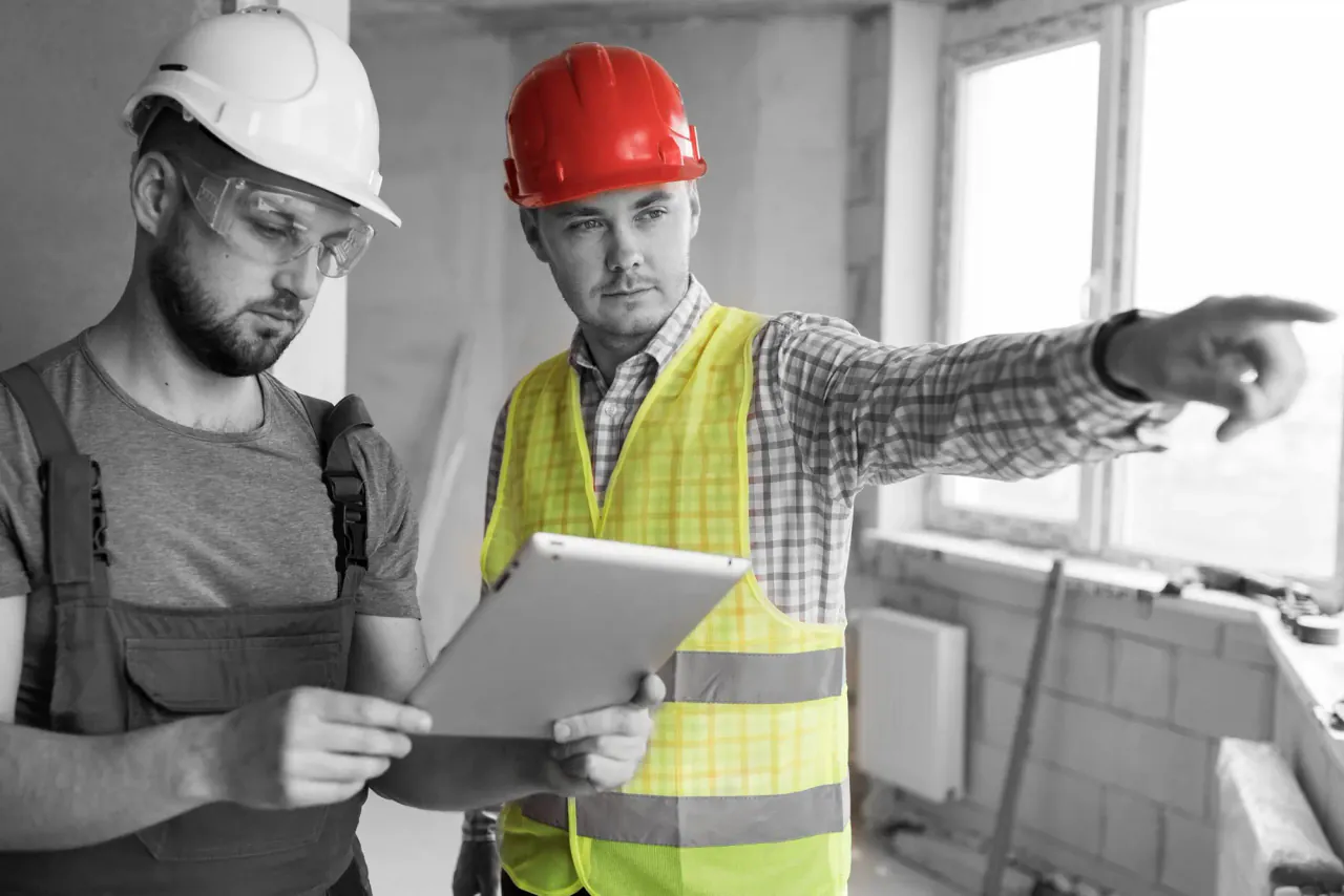 Operative in hi-vis, hard hat and safety glasses on a UK construction site