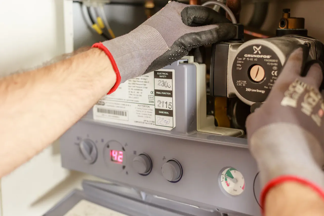 An engineer working inside a gas boiler