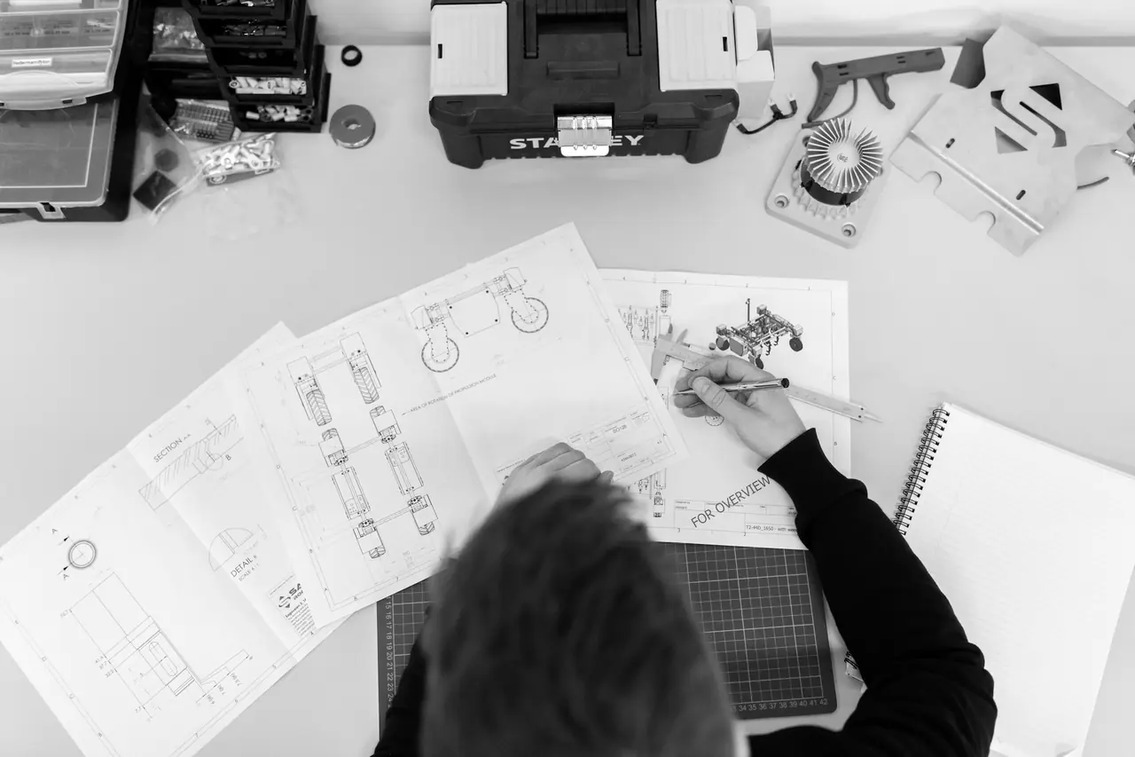 Technical drawings and tools on a workbench