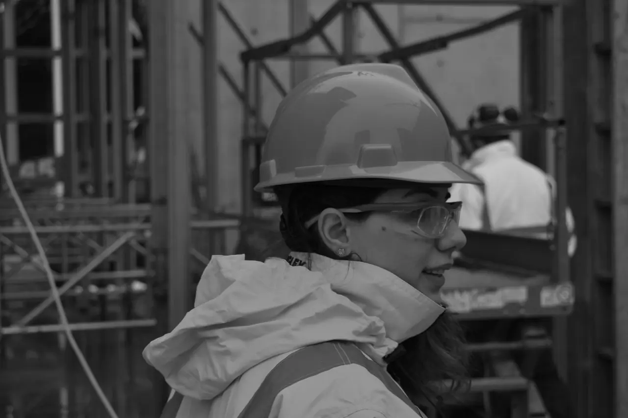 Operative in hi-vis, hard hat and safety glasses on a UK construction site