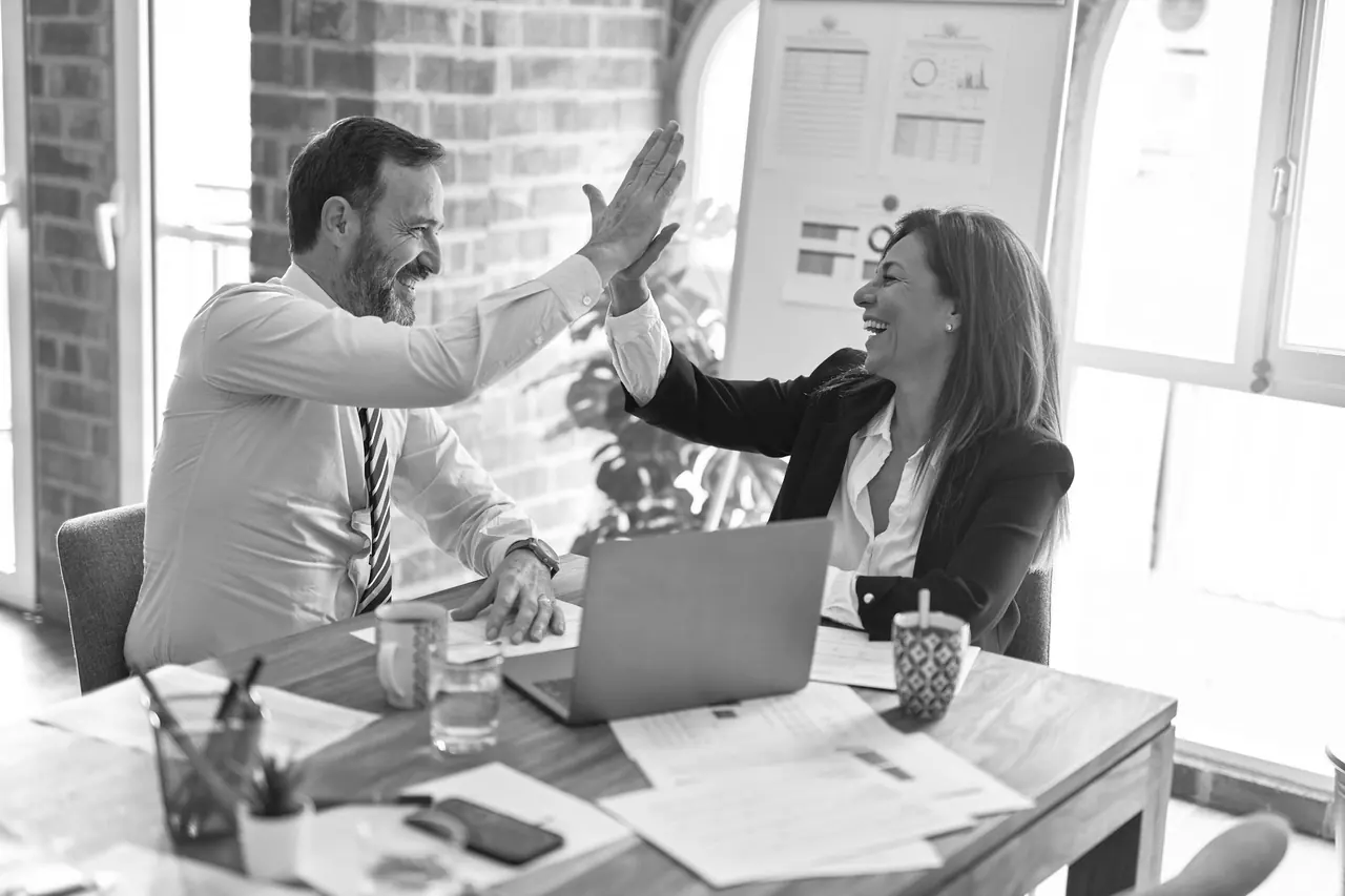 Two colleagues at a desk after reaching an agreement