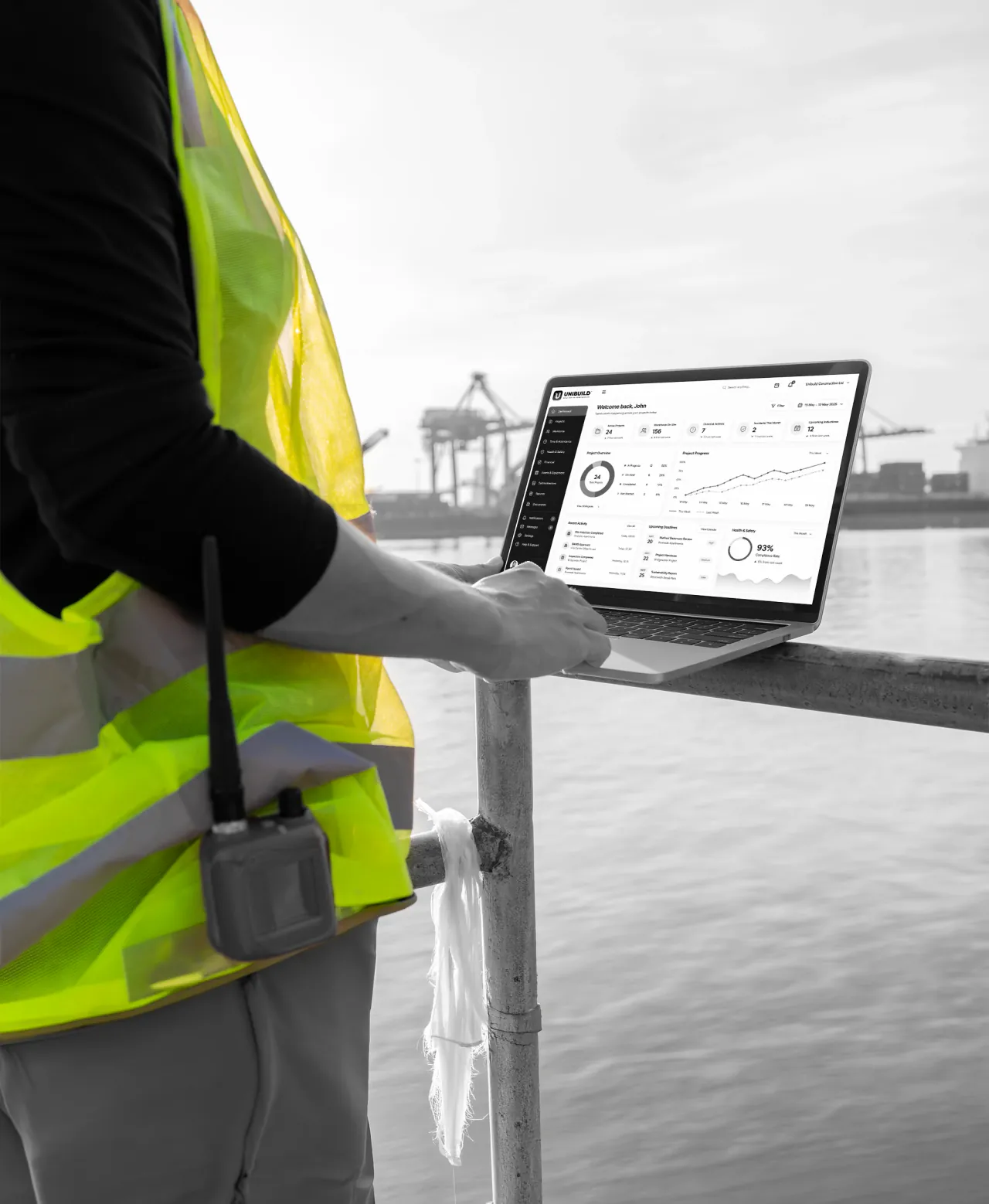 A supervisor on a quayside checking a dashboard on a laptop